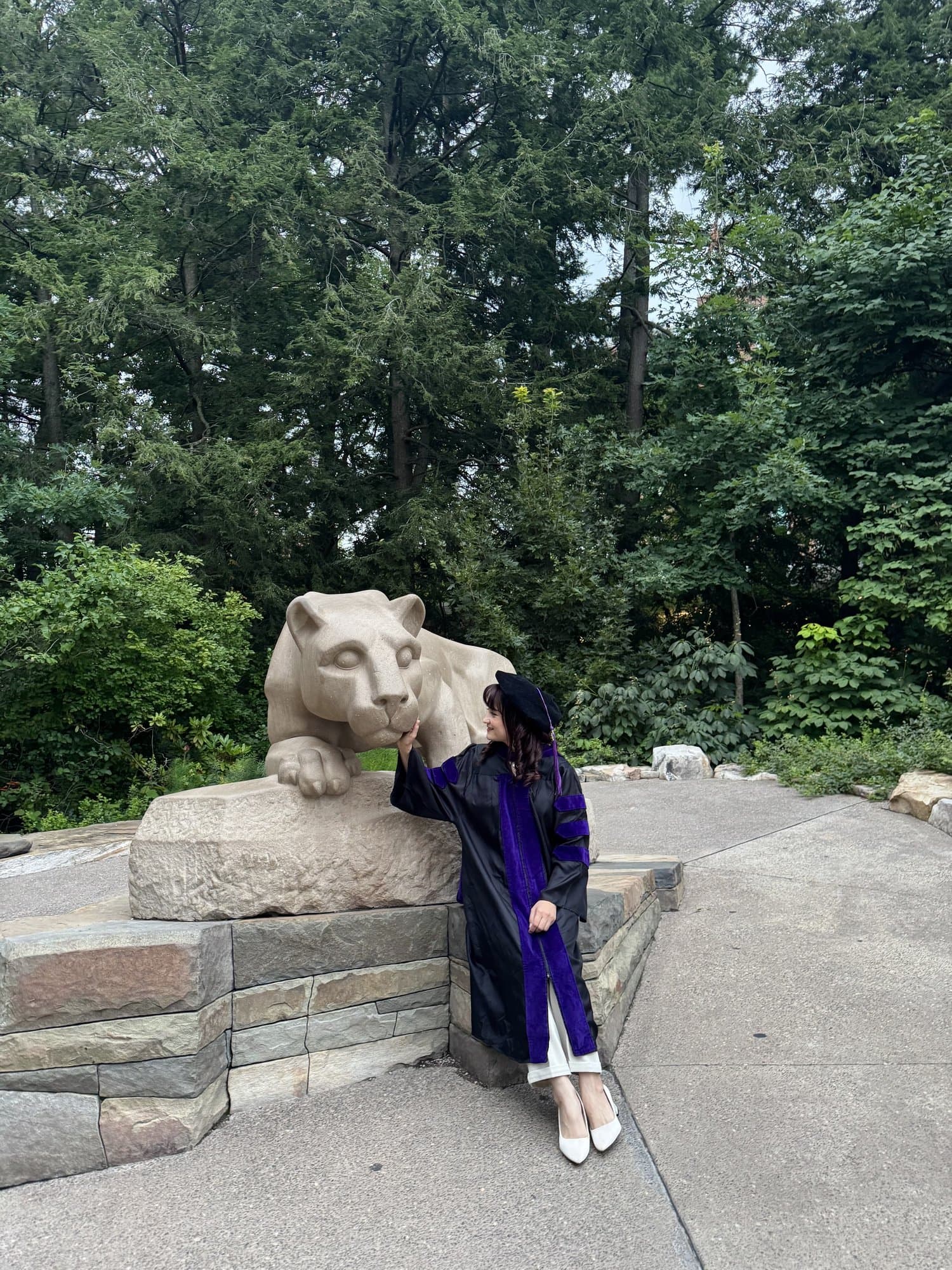Farangiz Razakova Penn State bitiruv libosida Nittany Lion haykali yonida